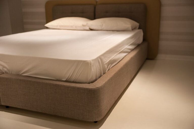 Cama minimalista con ropa de cama blanca