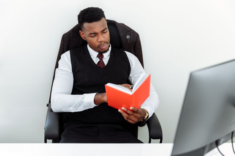 Hombre leyendo en oficina con silla ergonómica